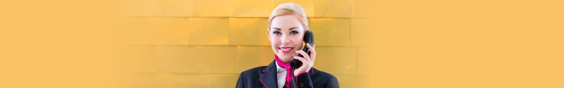 hotel receptionist with phone on front desk